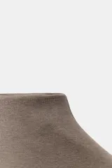 Top negro de tejido de punto, corte ajustado, con cuello alto y mangas sisa caídas.