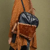 Mochila de cuero vacuno azul y marrón con estampado de víbora en los laterales. Tiene un bolsillo frontal con cierre, dos bolsillos laterales, interior forrado con bolsillo con cierre y bolsillo para el móvil. Las correas son removibles.