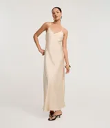 Vestido largo (midi) color beige claro, estilo slip dress, con escote en V y breteles finos ajustables. Presenta un recorte sutil en el área del busto.
