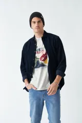 Camisa de pana color beige, de corte regular, con cuello clásico y cierre frontal con botones. Confeccionada en algodón.