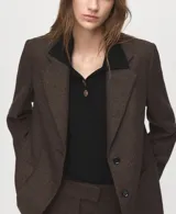 Jersey de punto color negro con cuello polo, cierre frontal parcial con botones y mangas largas.