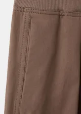 Pantalón balloon de tiro alto color marrón, confeccionado en algodón, con cintura ajustable con elástico, pinzas en la parte delantera, bolsillos laterales y bajos fruncidos con elástico.