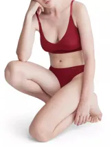 Bombacha tipo colaless de microfibra suave color rojo, diseño de talle medio con bordes sin costuras cortados a láser y logo de Calvin Klein estampado en la cadera.