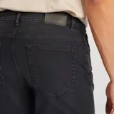 Pantalón jean de corte slim color gris oscuro, con bolsillos delanteros y traseros, y cierre con cremallera y botón.