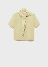 Jersey de punto fino color verde claro, con cuello redondo y manga corta. Presenta un diseño recto y un detalle de pañuelo integrado en el cuello.