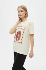 Remera marrón de manga corta y cuello redondo, de corte holgado, con estampado frontal alusivo a frutos del mar y texto "fruits de mer".