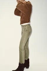 Jeans de tiro alto con diseño cropped flare, cinco bolsillos y bajo deshilachado. Cierre frontal con cremallera y botón metálico.