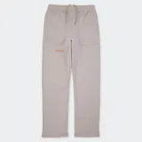 Pantalón de jogging color beige con bolsillos laterales y logo Converse estampado en color naranja en la pierna izquierda.