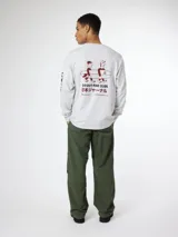 Camiseta gris de manga larga con cuello redondo y puños ajustados. Estampado en la espalda con dos personas cargando una tabla de surf y texto en inglés y japonés. Logo de la marca en la manga izquierda.