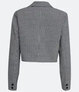Blazer corto con estampado de pata de gallo en blanco y negro, con cuello solapa, cierre cruzado con botones y bolsillos delanteros simulados.