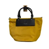Cartera tipo tote de la marca David Jones, confeccionada en tela color mostaza con detalles en cuero sintético negro en las asas y en el panel frontal, donde se encuentra el logo grabado.