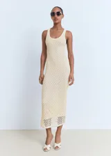 Vestido midi de crochet color beige, sin mangas, con tirantes anchos y cuello escotado. Diseño recto con forro interior.