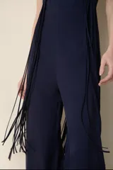 Mono largo azul con escote halter cruzado y detalle de flecos en los laterales.