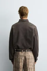 Sudadera de corte boxy fit con cuello subido y cierre frontal de cremallera. Presenta mangas largas, acabado efecto lavado y puños y ruedo en rib.