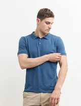 Remera polo azul marino con estampado de pequeños puntos blancos, cuello clásico con tres botones y mangas cortas.