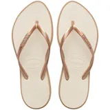Ojotas Havaianas modelo Slim Point, con base color crema y tiras finas en tono bronce metalizado.