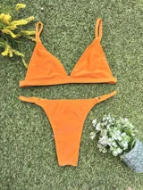 Conjunto de bikini naranja, con corpiño triangular fijo y bombacha colaless regulable.