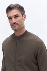 Campera de tejido de punto liviano color beige, con cierre frontal completo y cuello alto tipo bomber. Presenta un pequeño logo bordado en el pecho y puños acanalados.