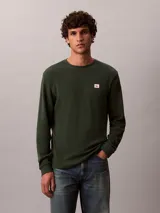 Remera de manga larga Calvin Klein en color verde oscuro, confeccionada en tejido térmico de punto con textura de nido de abeja. Cuenta con cuello redondo, puños acanalados y un pequeño parche con el logo de la marca en el pecho.