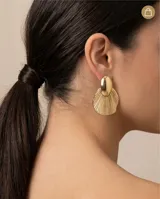 Caravanas de acero con baño de oro, compuestas por una pieza superior ovalada lisa y una pieza inferior en forma de abanico con textura estriada.