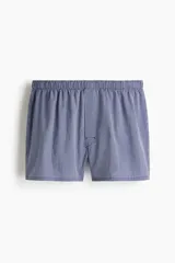 Pack de cuatro calzoncillos tipo boxer de tela de algodón suave, con cintura elástica y cierre de botones. El set incluye un modelo liso azul marino, uno con microestampado, uno a cuadros y uno a rayas verticales.