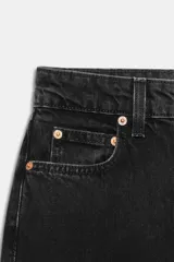Jeans de tiro alto con corte mom fit, cinco bolsillos y cierre frontal con cremallera y botón metálico.