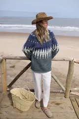Sweater de lana merino tejido a mano con diseño de jacquard en tonos azules y verdes. Presenta cuello redondo y mangas largas con un calce holgado.
