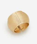 Pulsera tipo brazalete ancho de diseño maxi, confeccionada en metal con acabado texturizado de líneas horizontales y cierre de bisagra.