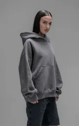 Hoodie oversize de corte crop, color gris oscuro, confeccionado en frisa de algodón. Presenta capucha forrada, bolsillo tipo canguro frontal y puños elásticos.