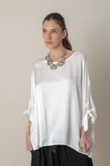 Blusa italiana color blanco de calce holgado, con mangas 3/4 con lazos en los puños y cuello redondo. Talle único.