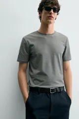 Camiseta de corte ajustado confeccionada en tejido de algodón con elasticidad, cuello redondo y manga corta.