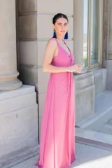 Vestido largo rosado con escote en V, tirantes anchos y diseño drapeado en el frente.