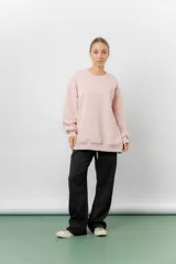 Buzo oversize de cuello redondo, confeccionado en algodón suave con interior frizado. Presenta un diseño de líneas simples, corte relajado y mangas largas con puños ajustados.