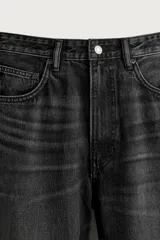 Jeans de denim de algodón en color azul con efecto desgastado, tiro medio y corte recto de ajuste holgado (loose fit). Cuenta con diseño clásico de cinco bolsillos y cierre frontal con cremallera y botón.