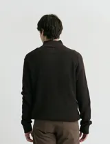 Cardigan de punto color azul marino, con cuello alto y cierre frontal parcial. Presenta diseño de punto inglés en cuerpo y mangas, con terminaciones en punto canalé en cuello y puños.