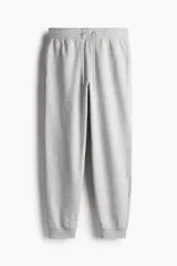 Pantalón de jogging gris de felpa liviana de mezcla de algodón con interior cepillado suave. Modelo con elástico revestido y cordón para ajustar en la cintura, bolsillos en las costuras laterales y puños acanalados.