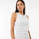 Vestido midi de canalé color beige con estampado floral azul, sin mangas, con cuello redondo y tajo lateral en el dobladillo.