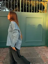 Camisa de corte oversize con estampado de rayas verticales en color verde y blanco, manga larga con puños abotonados y cuello clásico.