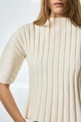 Top de punto acanalado color negro, con cuello redondo y mangas cortas abullonadas.