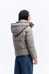 Campera puffer negra con capucha, diseño corto y acolchado, cierre frontal con botones a presión y puños ajustados.