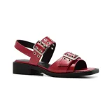 Sandalias bajas negras de charol con hebillas plateadas y suela plana.