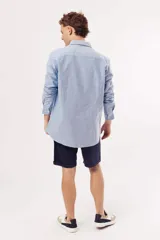 Camisa de manga larga para hombre, color azul claro jaspeado, con cuello clásico y botones blancos. Corte ajustado (slim fit).