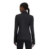 Remera deportiva New Balance negra de manga larga con cuello alto y cierre de cremallera corto. Cuenta con orificios para los pulgares en los puños y logo reflectante en el pecho.
