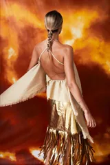 Pollera midi dorada con flecos en el ruedo.