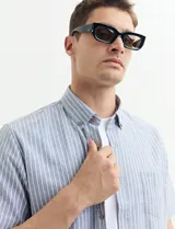 Camisa de manga corta con cuello abotonado y estampado a rayas verticales color beige y blanco.