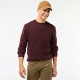 Sweater de punto con textura gofrada, color púrpura, de cuello redondo y manga larga con puños acanalados.