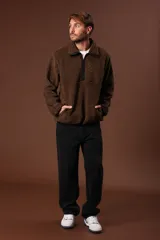 Cazadora de borreguillo color marrón, con cuello alto y cierre frontal parcial con cremallera. Presenta bolsillos laterales y diseño de manga larga.