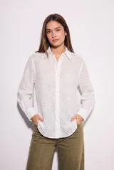Camisa de corte oversize confeccionada en algodón con diseño de broderie. Presenta cuello clásico, cierre frontal con botones y mangas largas con puños rectos.