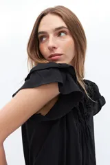 Blusa blanca de lyocell y algodón, con escote fruncido con volados y lazos.