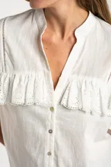 Blusa blanca de algodón con cuello mao, cierre frontal de botones y volados en los hombros con detalle de bordado inglés.